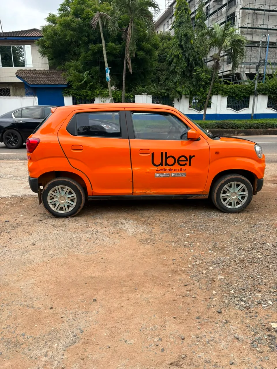 Une personne ouvre la portière arrière d’une voiture utilisée pour un trajet Uber.